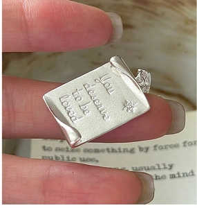 Macro detail of S925 silver rectangle pendant with You deserve to be loved engraving