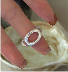 Macro shot of minimalist S925 sterling silver ring with oval cutout on finger