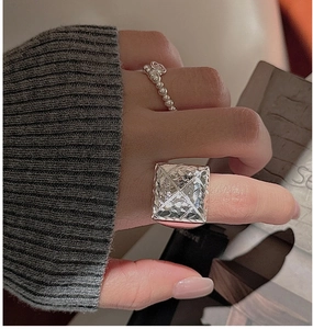 Detailed view of silver S925 ring with geometric CNC pyramid texture and bead band accent
