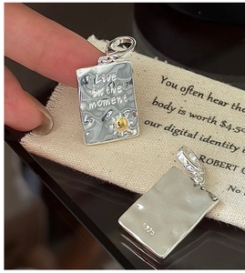 Macro shot of S925 sterling silver square pendant with Live in the moment engraving
