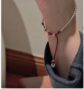 Macro shot of S925 sterling silver beads on an adjustable red braided rope bracelet