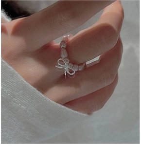 Detailed close-up of a bow pearl ring featuring pink freshwater pearls and silver bow