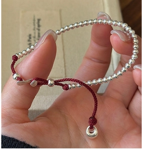 Detail of S925 silver beaded bracelet with red cord and bear-shaped charm toggle