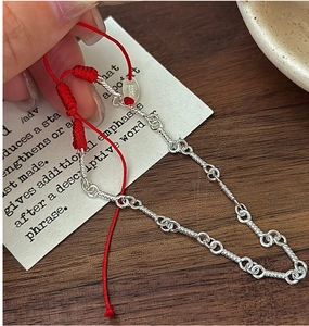Detail of S925 sterling silver chain bracelet with red braided rope and adjustable closure