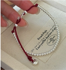 Close-up of S925 sterling silver beaded red string bracelet with a small elephant charm