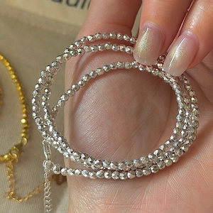 Collier minimaliste en argent sterling S925 à perles laser tenu à la main sur tissu