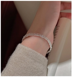 Macro view of multi-strand braided S925 sterling silver bracelet worn on wrist