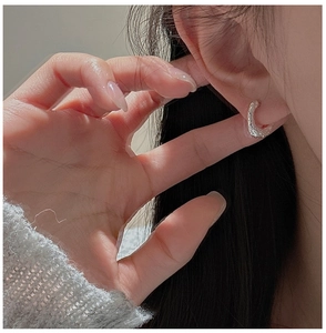 Détail macro de boucle d'oreille en argent S925 avec texture martelée faite à la main