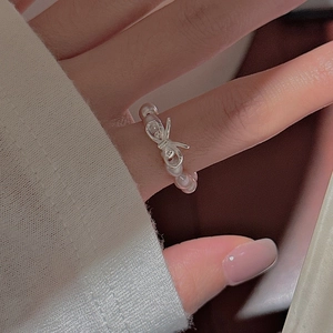S925 sterling silver bow ring with pink pearls worn on a finger in a close-up shot