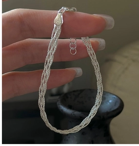 Close-up of braided silver bracelet with lobster clasp and adjustable extension chain