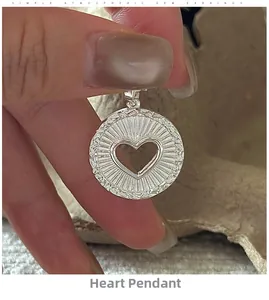 Détail macro du pendentif cœur en argent S925 avec texture soleil et bord tressé
