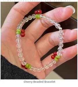 Close-up of cherry beaded bracelet with transparent beads and red fruit charms on wrist