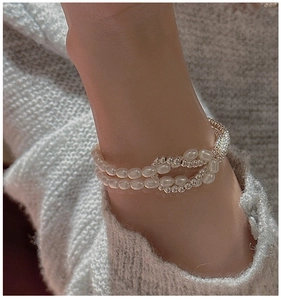 Vue détaillée du bracelet de perles noué avec perles argentées au poignet du mannequin