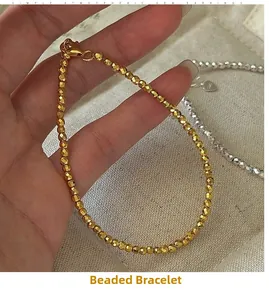 Detailed close-up of a faceted gold beaded bracelet with a secure lobster clasp closure