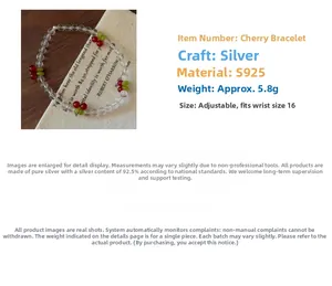 Detail of S925 silver beaded bracelet with cute cherry charms on rustic background