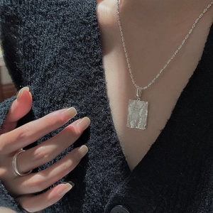 S925 sterling silver rectangular flower pendant necklace worn by a model in black cardigan