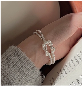 Détail d'un bracelet nœud en argent S925 avec perles élégantes porté au poignet