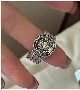 Close-up of S925 sterling silver vintage ring with embossed portrait and textured band