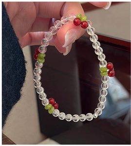 Detailed view of handmade beaded cherry bracelet with transparent crystal beads on wrist