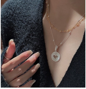 Détail de colliers superposés en argent S925 avec pendentif cœur sur un mannequin
