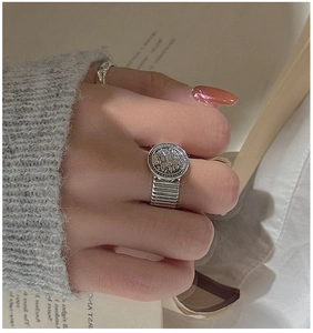 Detail of vintage S925 sterling silver wide band ring with round relief coin design