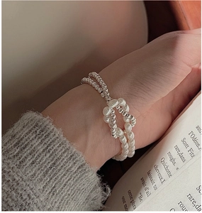 Détail d'un bracelet en argent S925 avec perles baroques et design noué porté au poignet