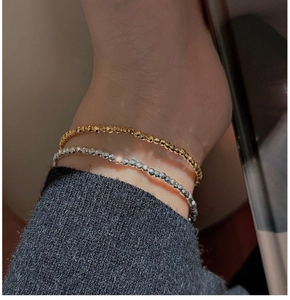Macro detail of minimalist S925 sterling silver laser beaded bracelets in gold and silver