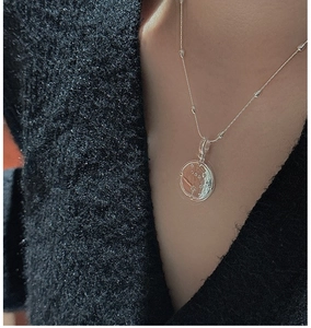 Détail du pendentif céleste en argent S925 sur une fine chaîne perlée élégante