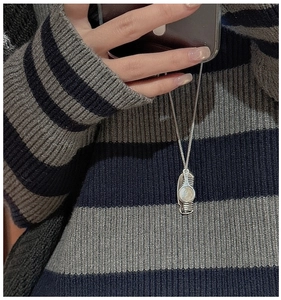 Detailed view of an S925 silver sweater necklace with a vintage comb-shaped pendant