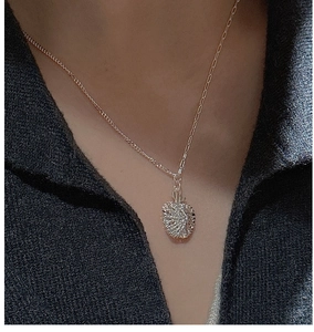 Close-up of S925 sterling silver apple necklace with textured shimmer pendant on model