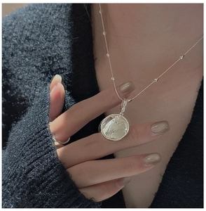 Détail du collier pendentif étoile en argent S925 porté par un modèle en pull noir