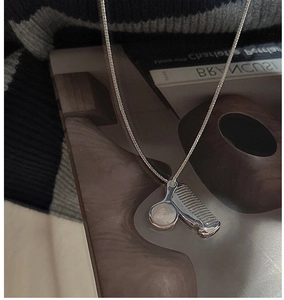 Macro detail of silver comb-shaped pendant with white moonstone on an S925 necklace