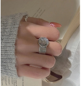 Macro detail of retro S925 sterling silver ring with round portrait medallion and relief
