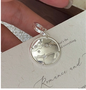 Détail macro du pendentif en argent S925 avec relief de chèvre et oxydes de zirconium
