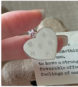 Close-up of S925 sterling silver heart pendant with starburst patterns and zircons