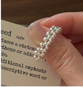 Macro shot of S925 sterling silver beaded ring with triple-row woven texture