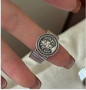 Close-up of vintage S925 silver ring featuring a relief portrait coin and textured band