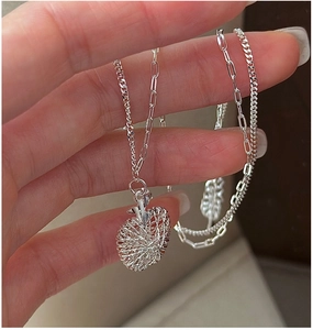 Detail showing an S925 silver apple pendant with woven texture on a layered mixed link chain