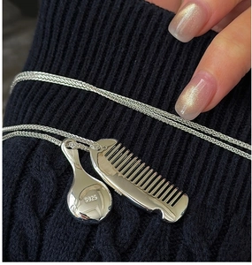 Macro shot of S925 sterling silver mini comb and mirror pendant with hallmark stamp