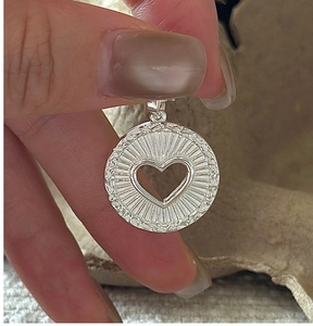 Vue détaillée d'un pendentif cœur en argent sterling S925 avec texture soleil
