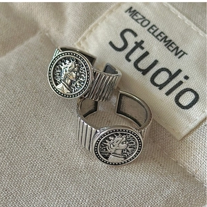 Macro shot of silver portrait coin rings with striped texture and adjustable band