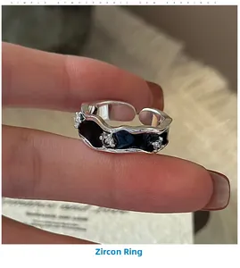 Close-up of S925 sterling silver open ring with black enamel waves and small zircon stones