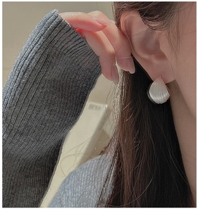 Detailed close-up of S925 sterling silver shell earrings with vintage radiating texture