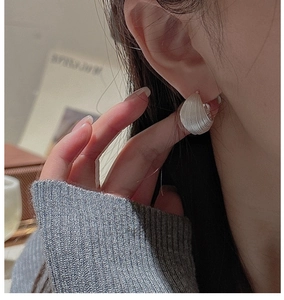 Close-up of S925 sterling silver hoop earrings with vintage texture on a model ear