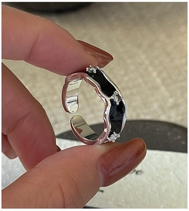 Detail of S925 sterling silver ring with black enamel waves and inlaid clear zircons
