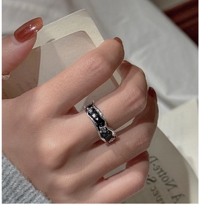 Macro shot of S925 silver wave ring with black enamel and sparkling star details