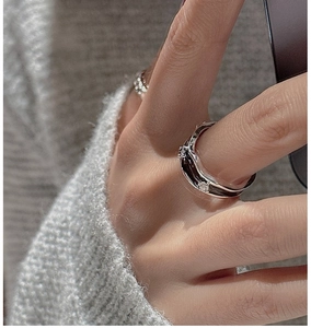 Macro detail of S925 silver wave ring with black enamel and zircon accents