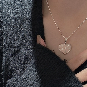 S925 silver heart necklace with pink matte inlay and star pattern on grey knitwear