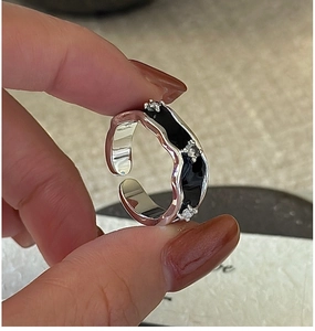 Macro detail of S925 silver wave ring with black enamel and three small zircons