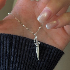 S925 sterling silver umbrella pendant necklace with beaded chain held against a black sleeve